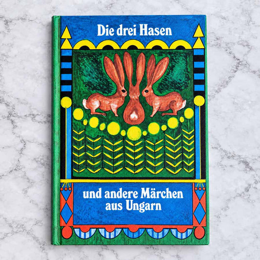 Die drei Hasen und andere Märchen aus Ungarn – Titelbild des Kinderbuchs mit drei Hasen und farbenfroher Illustration