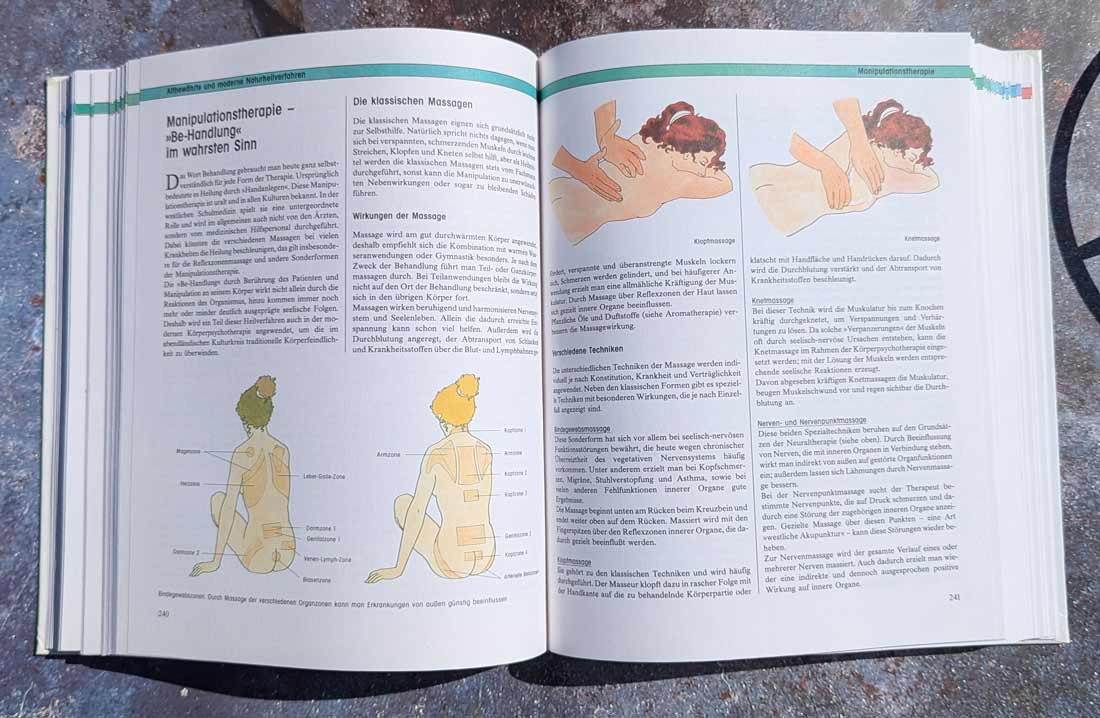 Naturheilkunde – aufgeschlagenes Hausbuch mit bebilderten Anleitungen zu Massage und natürlichen Anwendungen